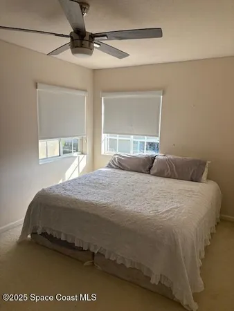 a bedroom with a bed and a large window
