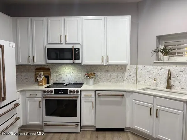a kitchen with white cabinets and stainless steel appliances
