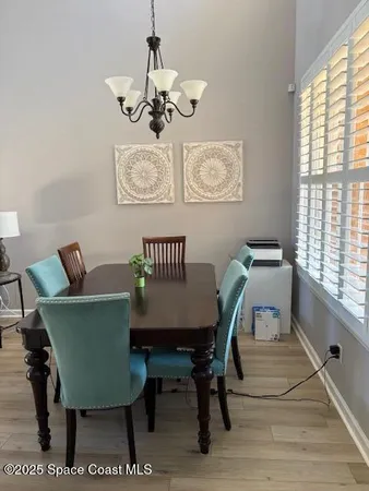 a view of a dining room with furniture a rug and wooden floor