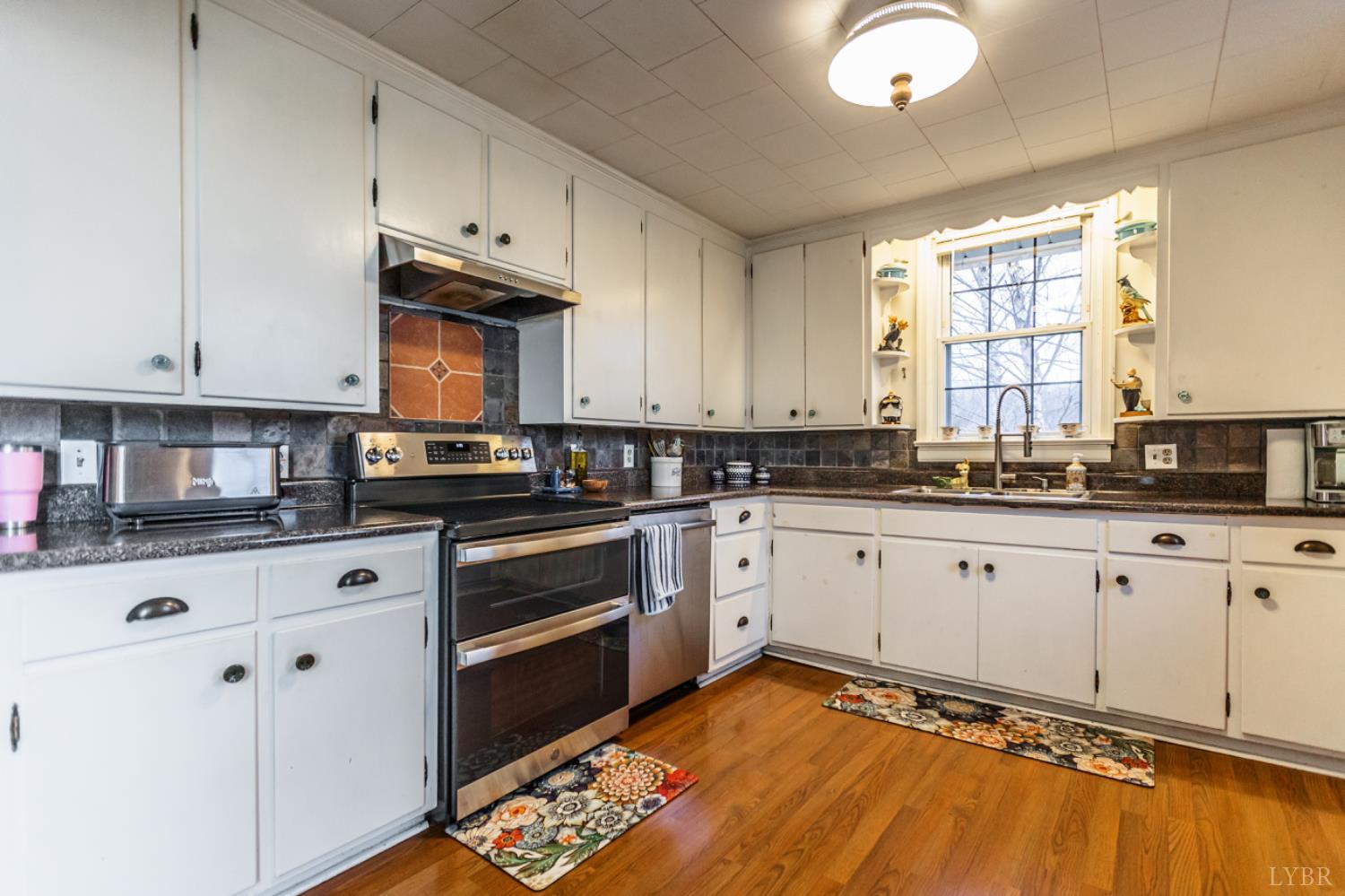 801 Purdum Mill Road Appomattox, VA 24522 - Photo 13 of 68 a kitchen with stainless steel appliances granite countertop a stove a sink and white cabinets