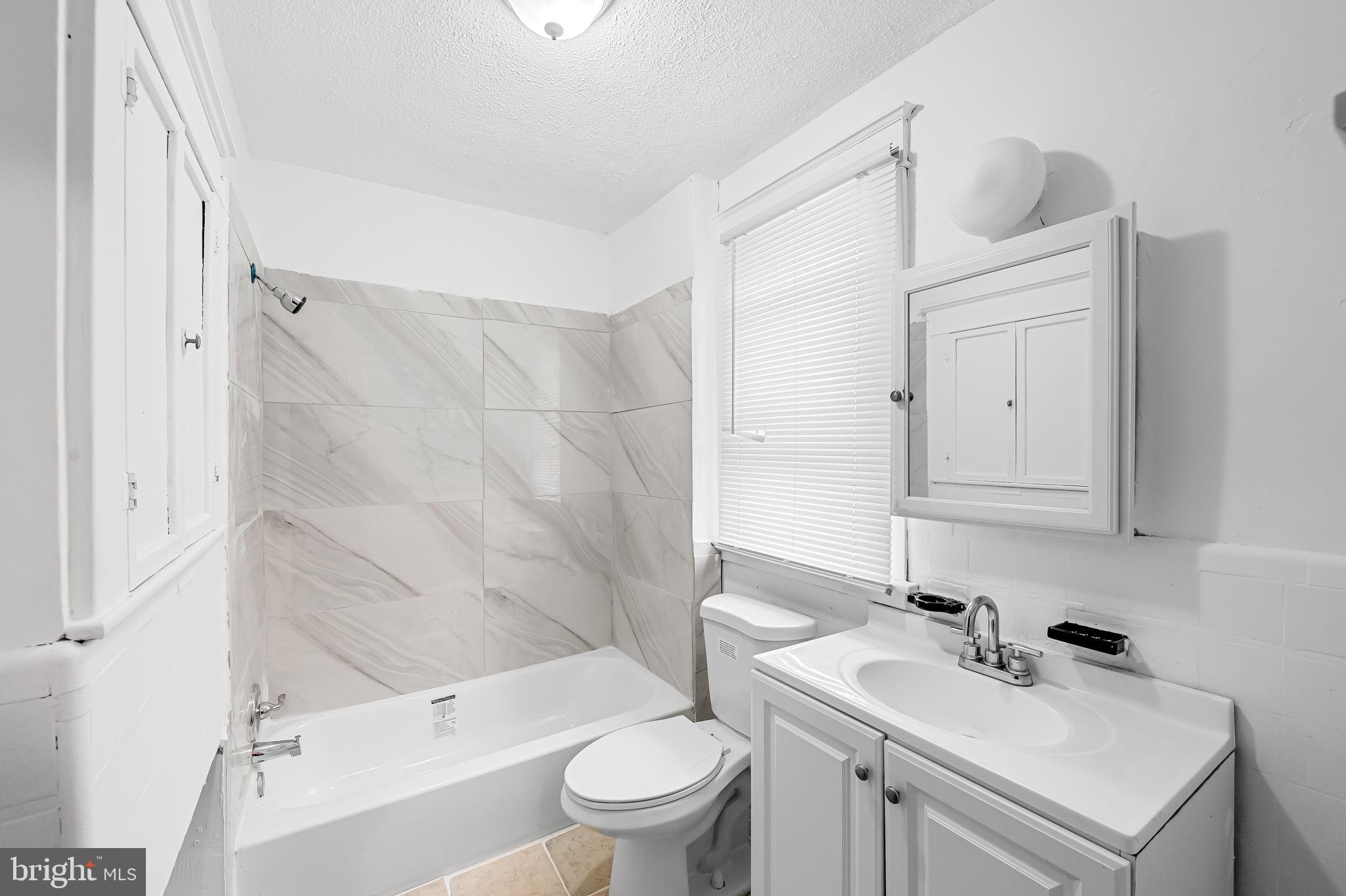 2908 East Cold Spring Lane Baltimore, MD 21214 - Photo 11 of 19 a bathroom with a sink toilet vanity and tub