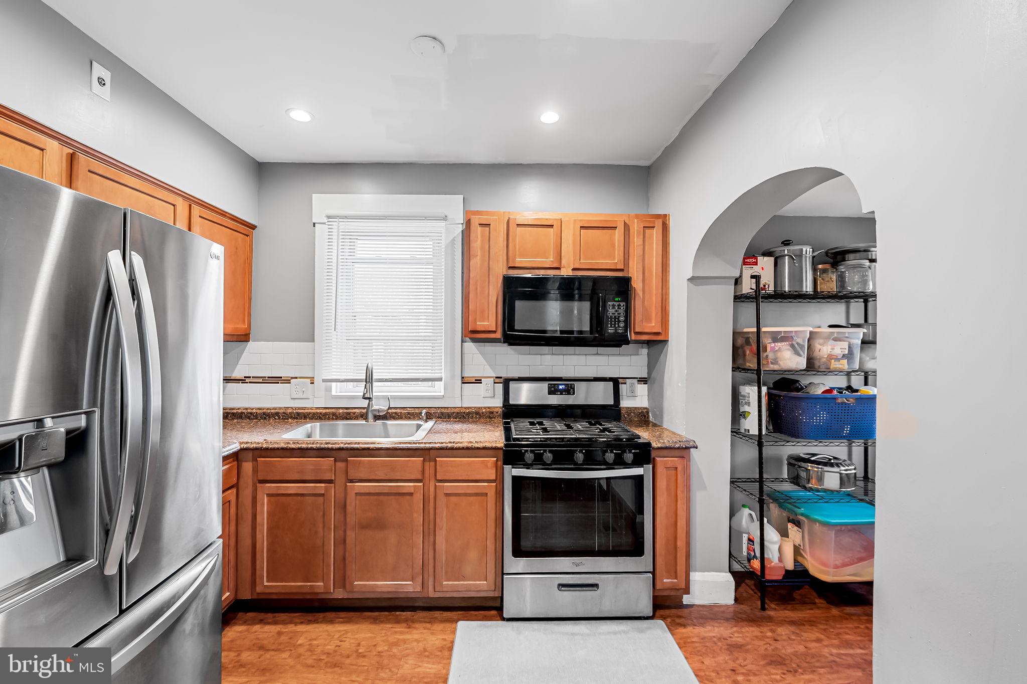 2908 East Cold Spring Lane Baltimore, MD 21214 - Photo 5 of 19 a kitchen with stainless steel appliances a stove a refrigerator a sink a stove and cabinets