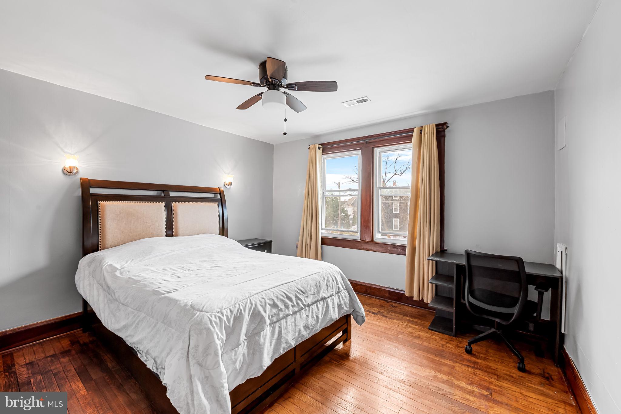 2908 East Cold Spring Lane Baltimore, MD 21214 - Photo 10 of 19 a bedroom with a bed wooden floor and window