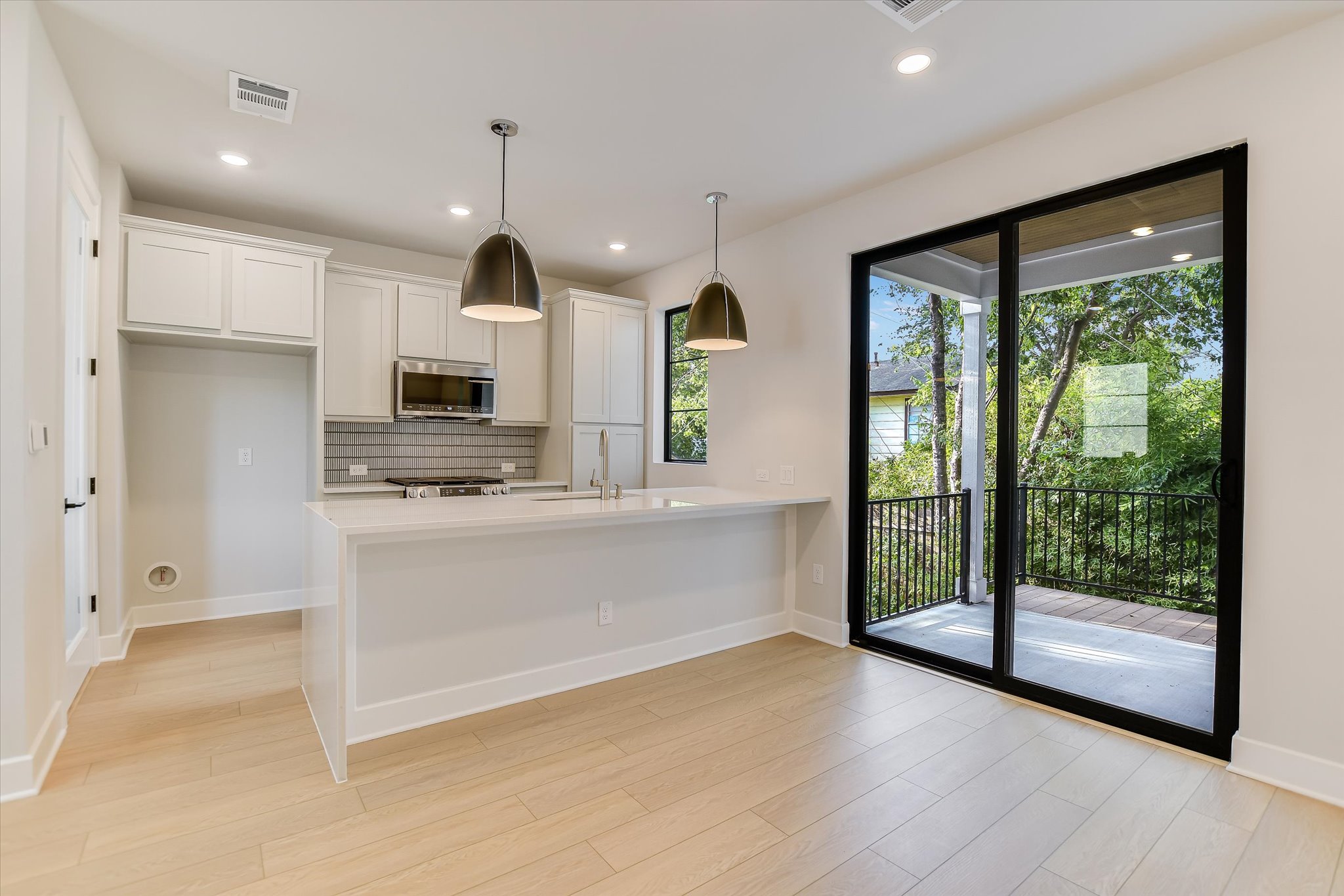 114 Lightsey Road, Unit 2 Austin, TX 78704 - Photo 5 of 14 Kitchen featuring decorative light fixtures, decorative backsplash, white cabinets, a peninsula, and recessed lighting
