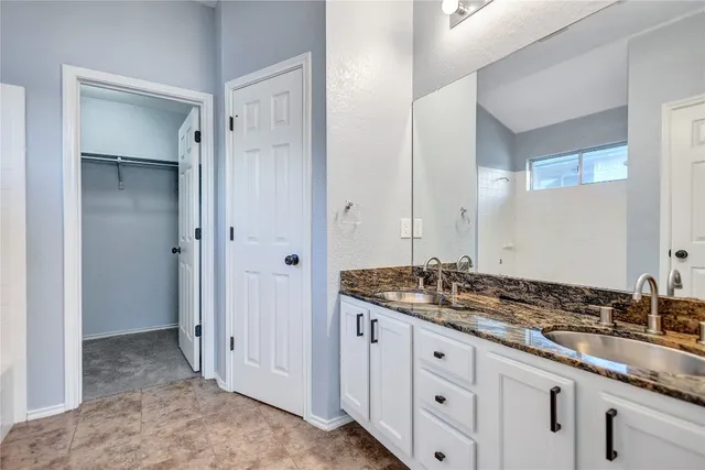 a spacious bathroom with a granite countertop sink and a mirror