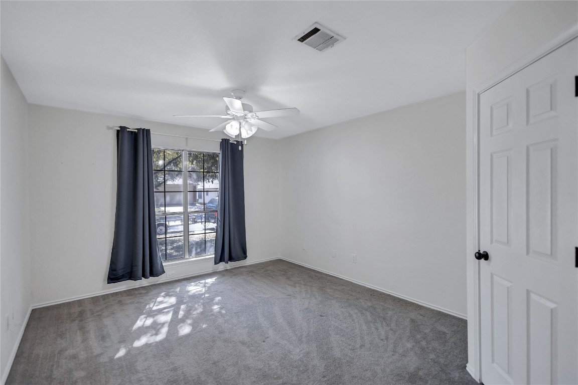 17616 Strontian Pass Pflugerville, TX 78660 - Photo 13 of 20 an empty room with windows and chandelier fan