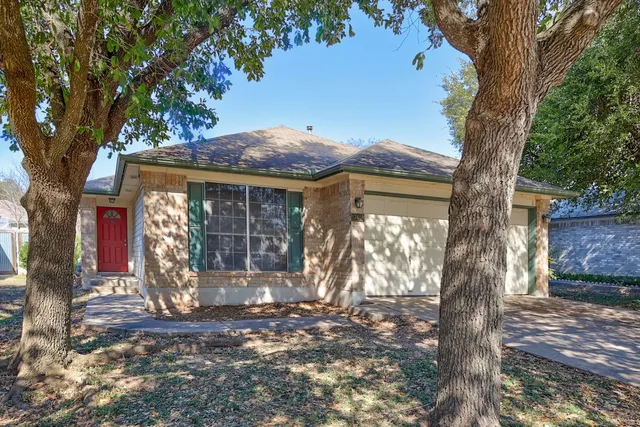 a front view of a house with a tree