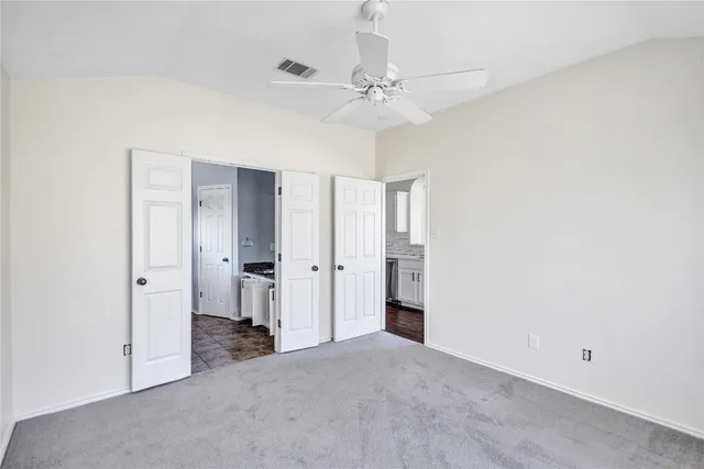 a view of a room with a ceiling fan and closet area