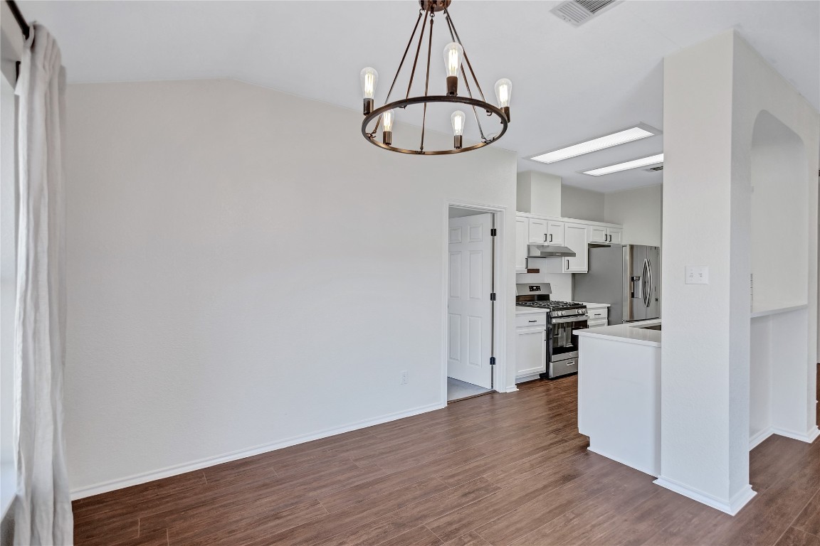 17616 Strontian Pass Pflugerville, TX 78660 - Photo 5 of 20 a kitchen with a refrigerator and a stove top oven