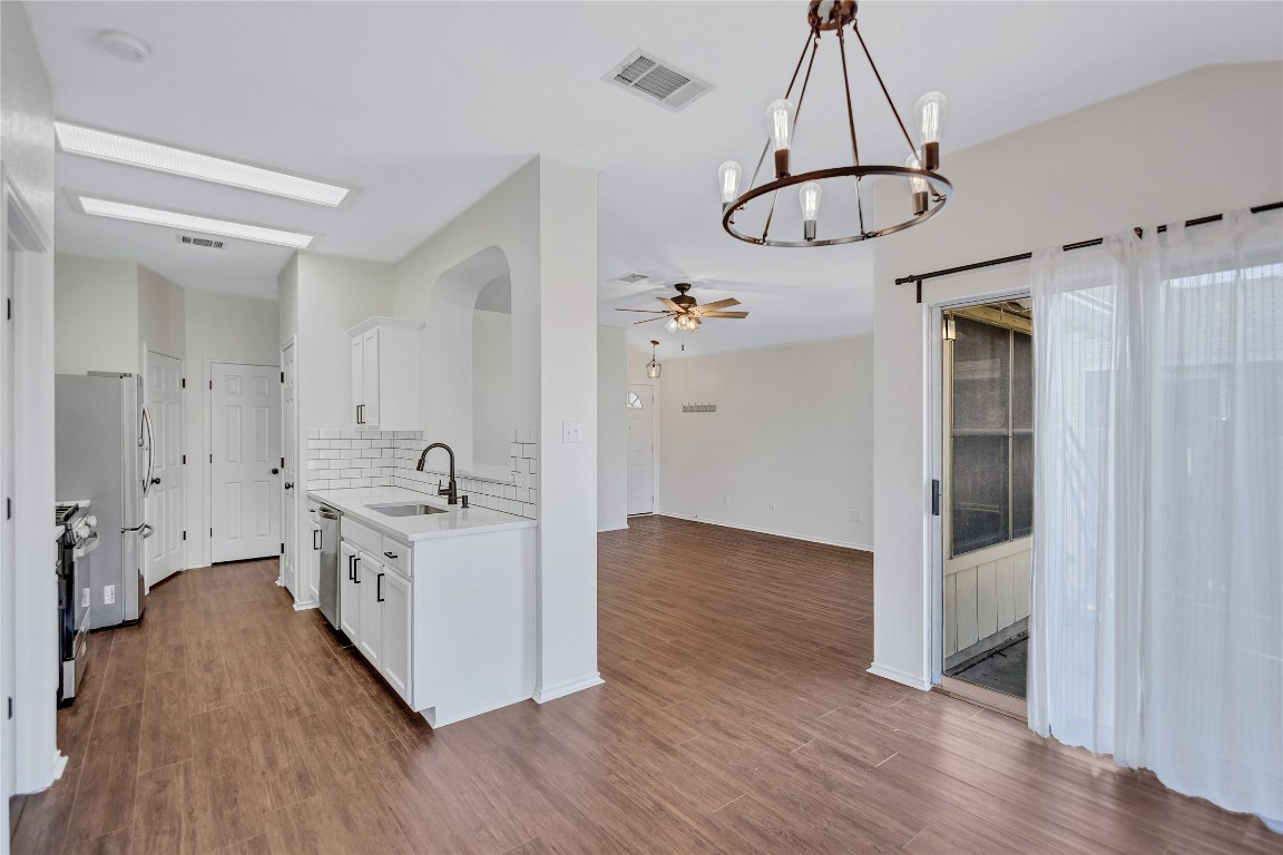 17616 Strontian Pass Pflugerville, TX 78660 - Photo 6 of 20 a kitchen with kitchen island stainless steel appliances a stove and wooden floor