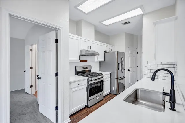 a kitchen with stainless steel appliances and a refrigerator