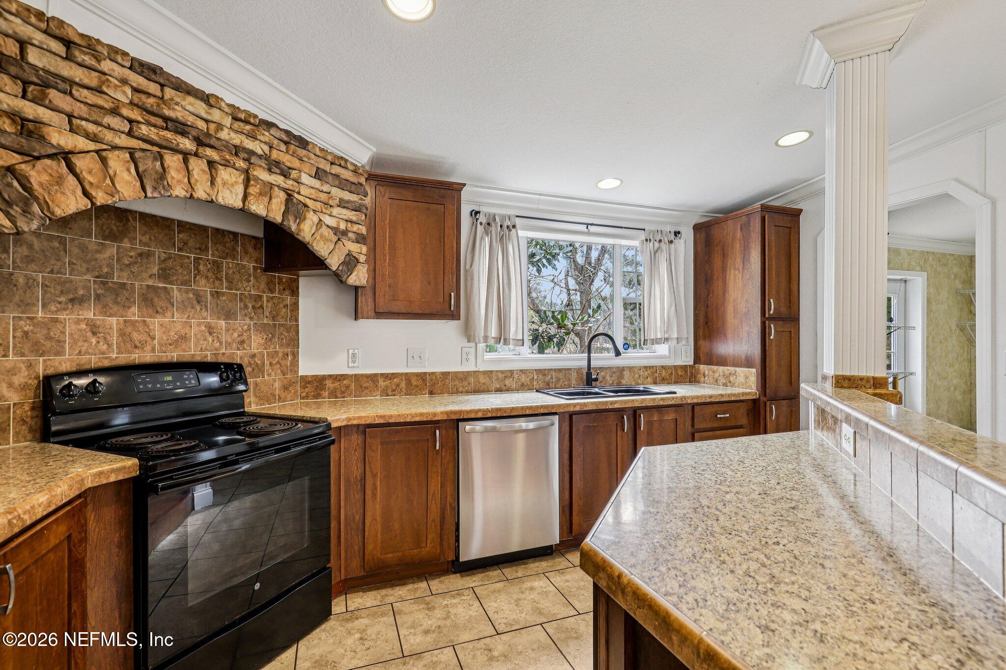 13725 Webb Road Jacksonville, FL 32218 - Photo 15 of 61 a kitchen with stainless steel appliances granite countertop wooden cabinets stove top oven and sink