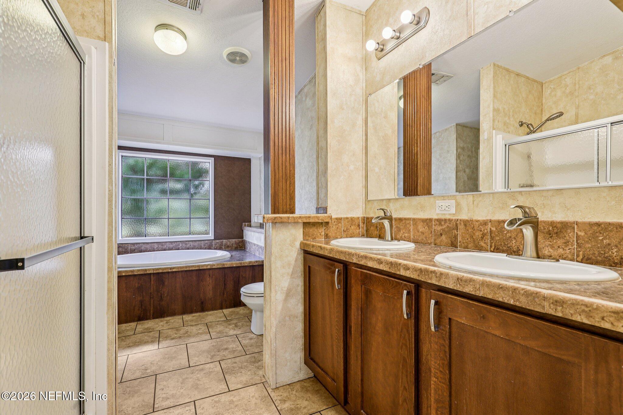 13725 Webb Road Jacksonville, FL 32218 - Photo 28 of 61 a bathroom with a granite countertop sink and a mirror