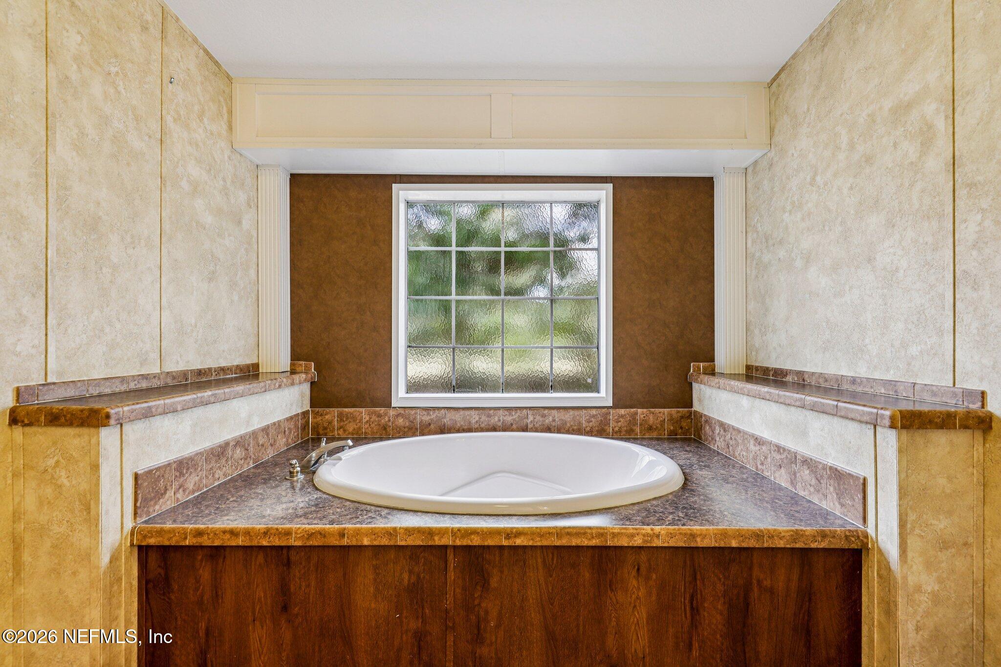 13725 Webb Road Jacksonville, FL 32218 - Photo 30 of 61 a bathroom with a granite countertop sink and mirror