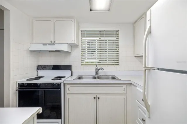 a kitchen with stainless steel appliances a stove a sink and a refrigerator