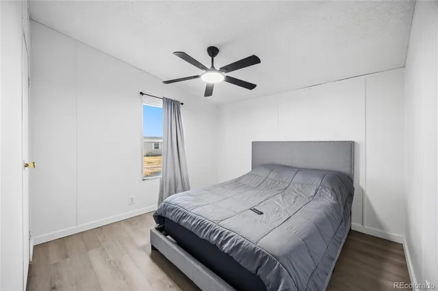 a bedroom with a bed and a ceiling fan