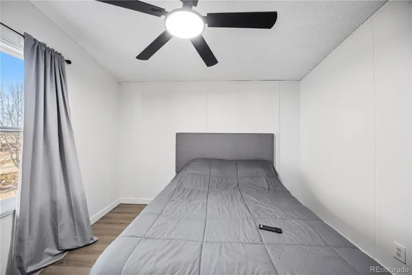 en empty room with wooden floor and windows