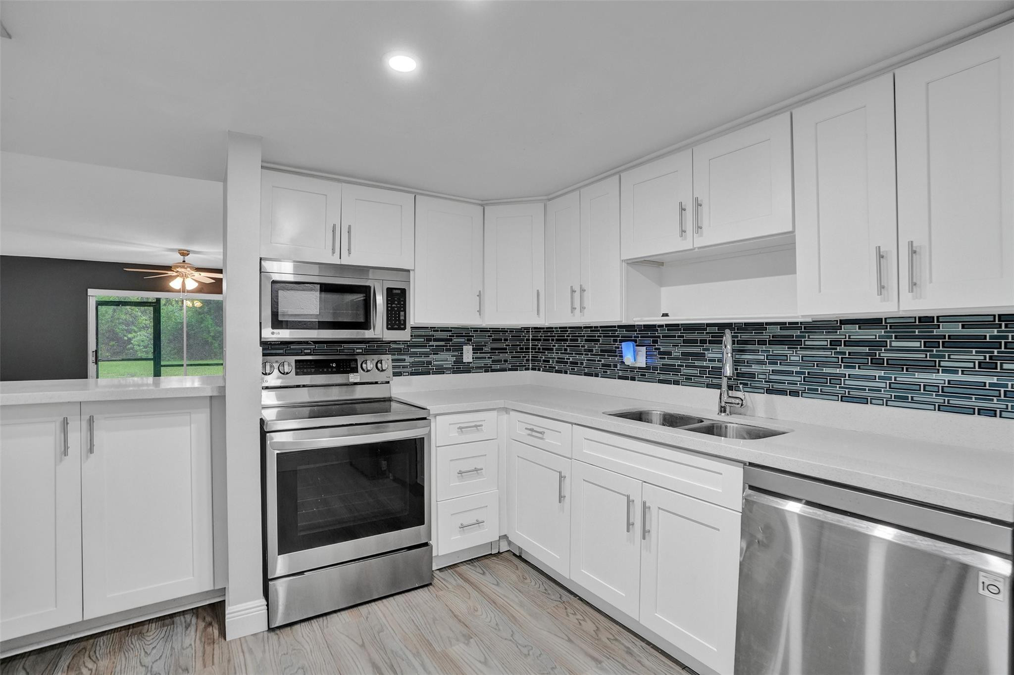 3100 Riverside Drive, Unit 109 Coral Springs, FL 33065 - Photo 1 of 28 a kitchen with white cabinets stainless steel appliances and sink
