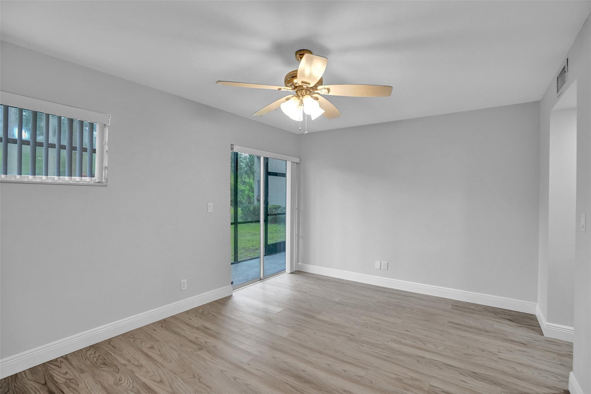 3100 Riverside Drive, Unit 109 Coral Springs, FL 33065 - Photo 11 of 28 a view of an empty room with wooden floor and a window