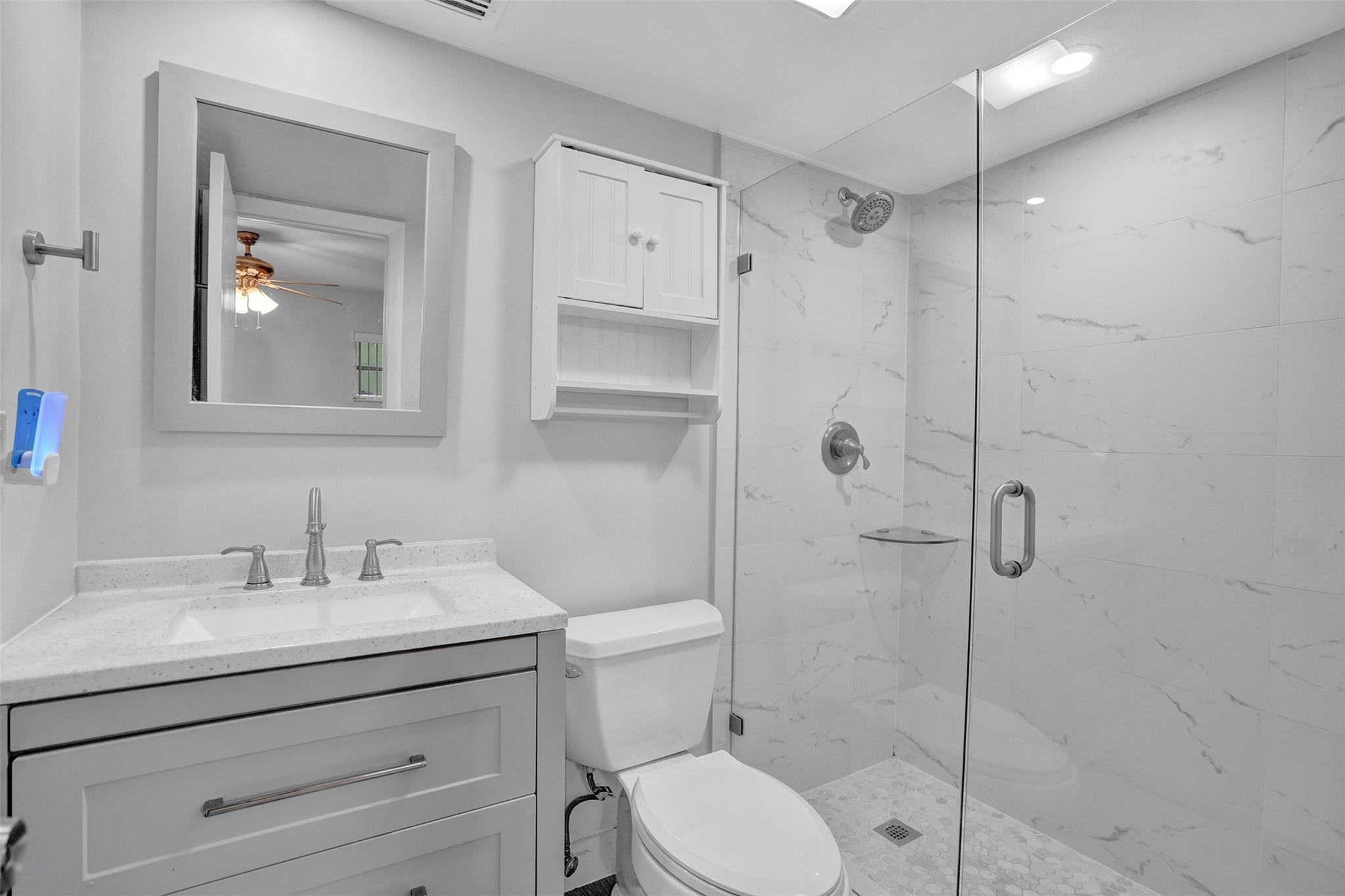 3100 Riverside Drive, Unit 109 Coral Springs, FL 33065 - Photo 12 of 28 a bathroom with a shower sink vanity and toilet