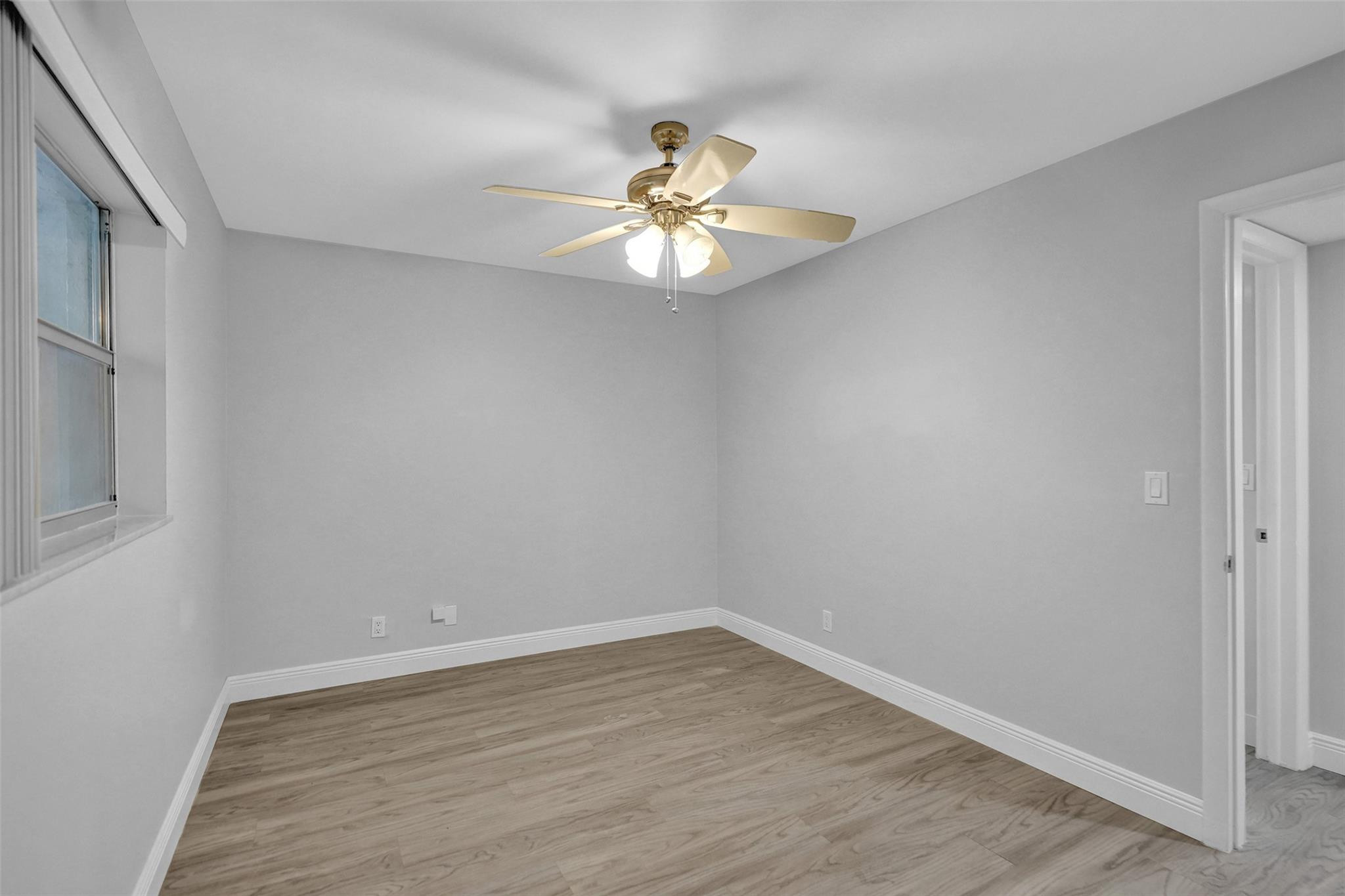 3100 Riverside Drive, Unit 109 Coral Springs, FL 33065 - Photo 15 of 28 wooden floor in an empty room with a window