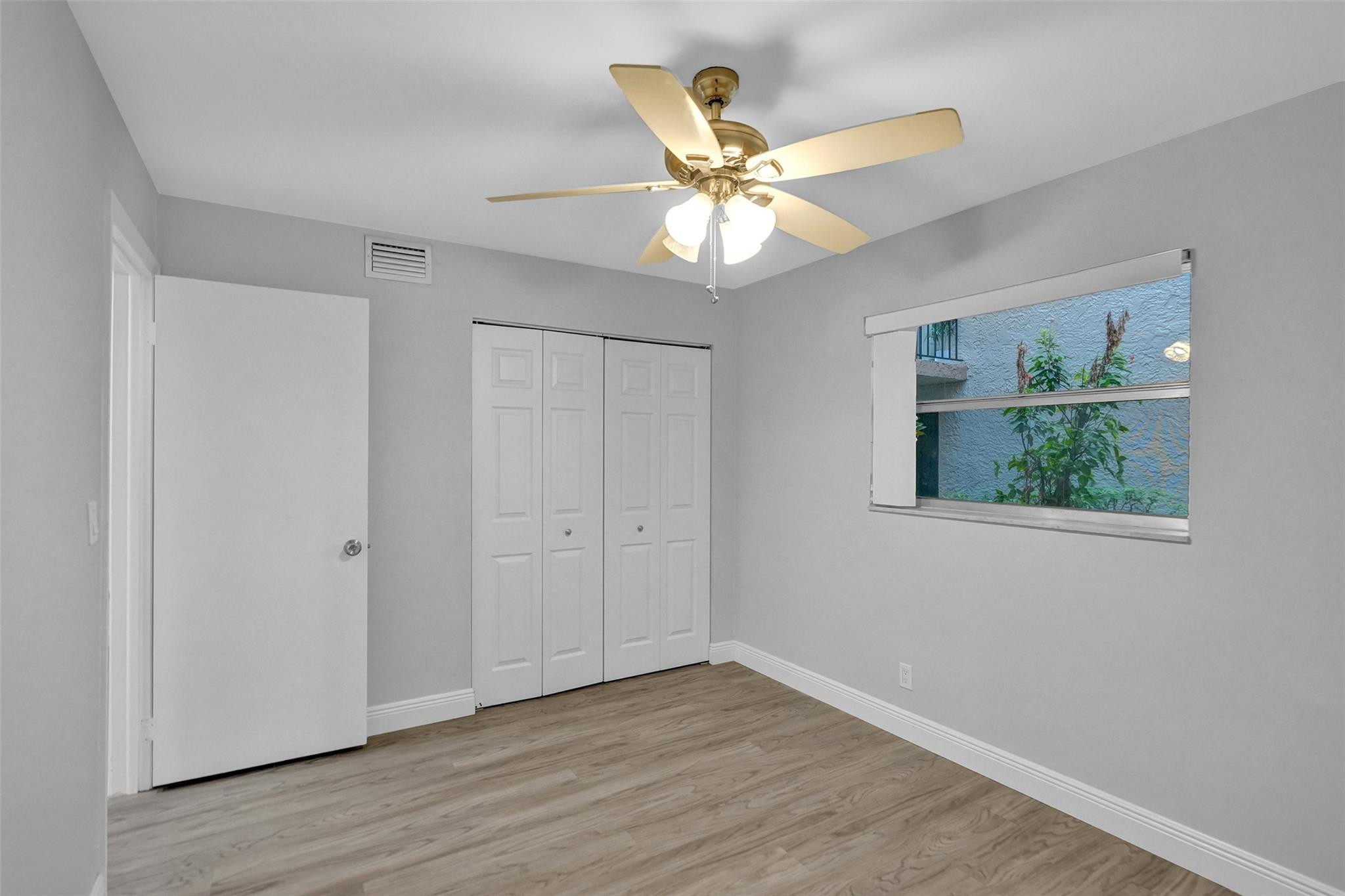 3100 Riverside Drive, Unit 109 Coral Springs, FL 33065 - Photo 16 of 28 a view of an empty room with wooden floor and a window