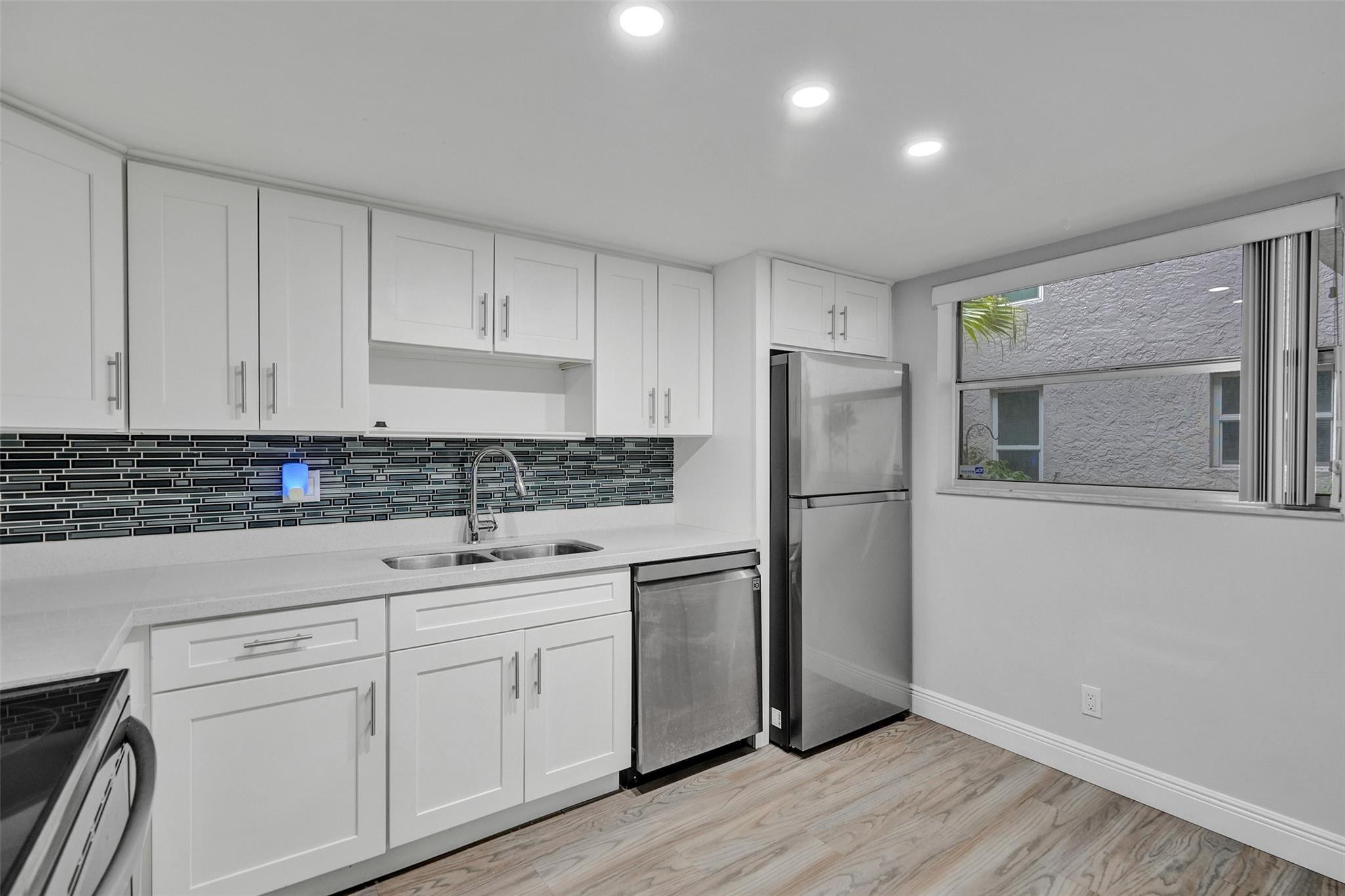 3100 Riverside Drive, Unit 109 Coral Springs, FL 33065 - Photo 2 of 28 a kitchen with a refrigerator sink and cabinets