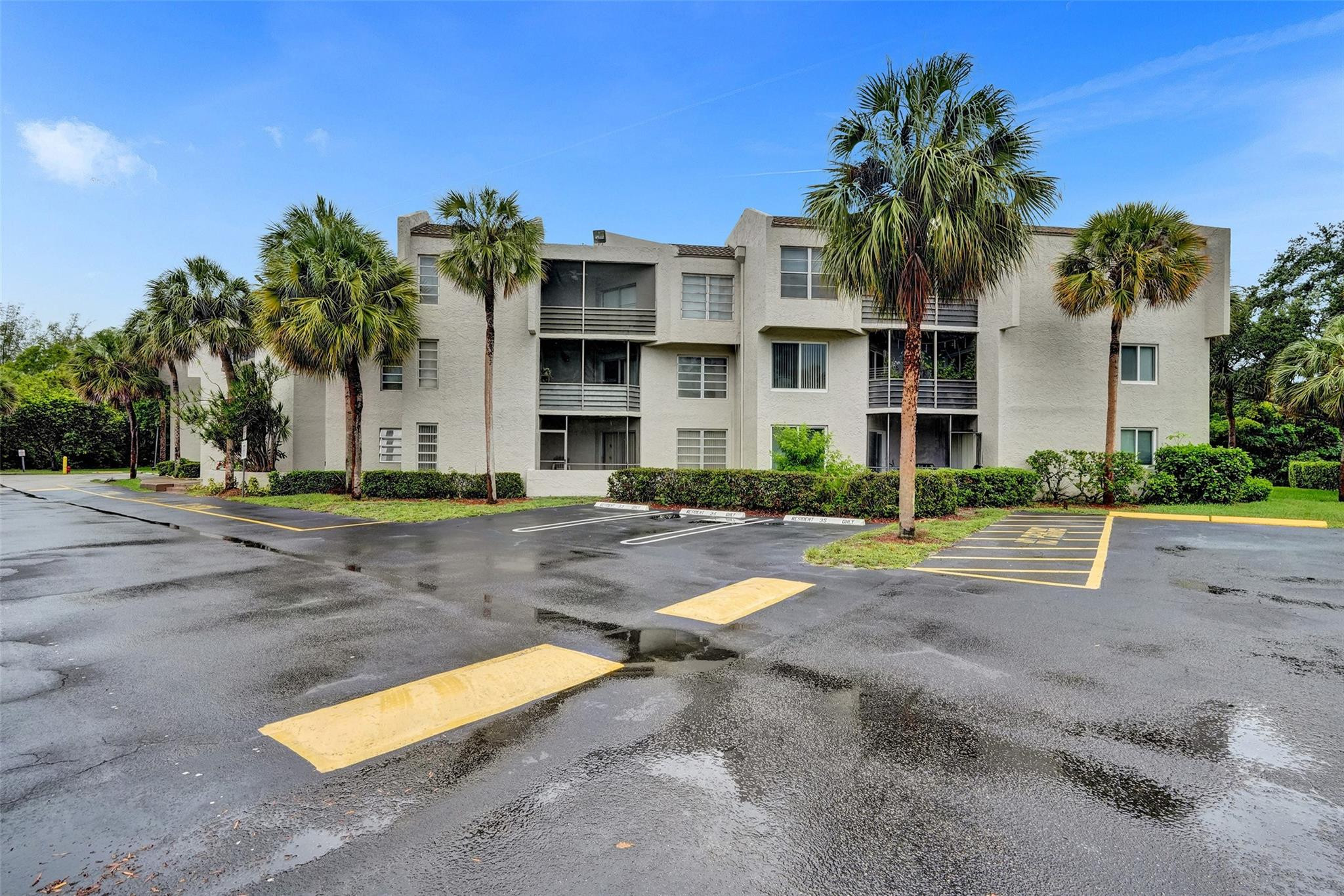 3100 Riverside Drive, Unit 109 Coral Springs, FL 33065 - Photo 26 of 28 a front view of a house with a yard and palm trees