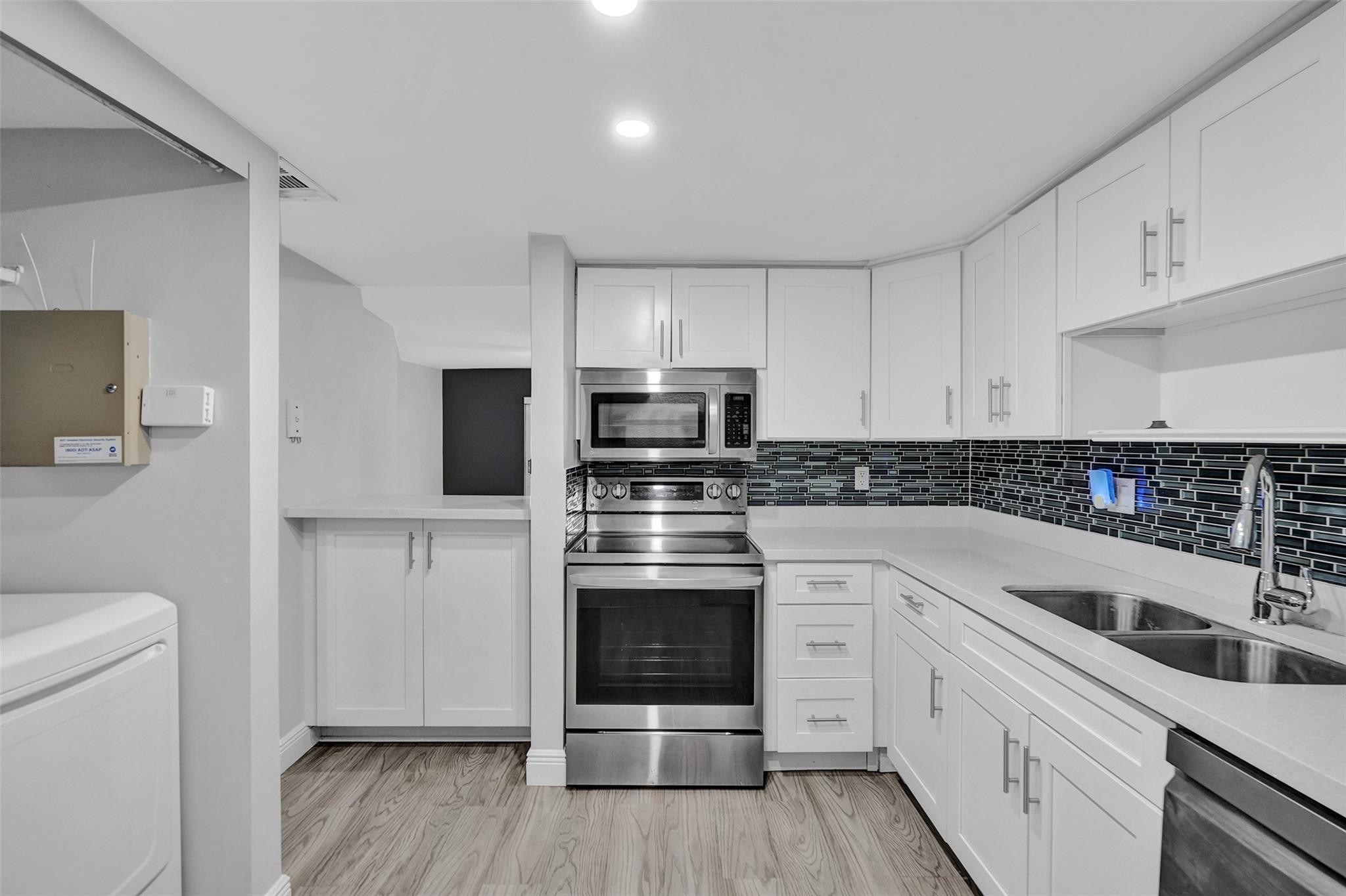 3100 Riverside Drive, Unit 109 Coral Springs, FL 33065 - Photo 3 of 28 a kitchen with granite countertop white cabinets and white stainless steel appliances