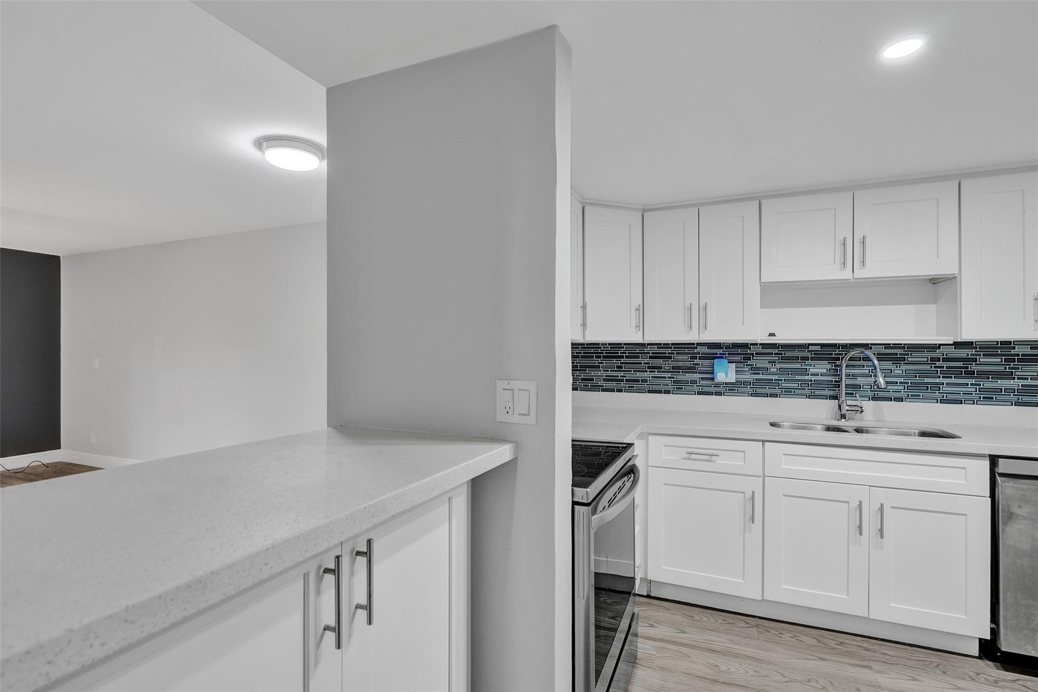 3100 Riverside Drive, Unit 109 Coral Springs, FL 33065 - Photo 5 of 28 a kitchen with white cabinets sink and dishwasher