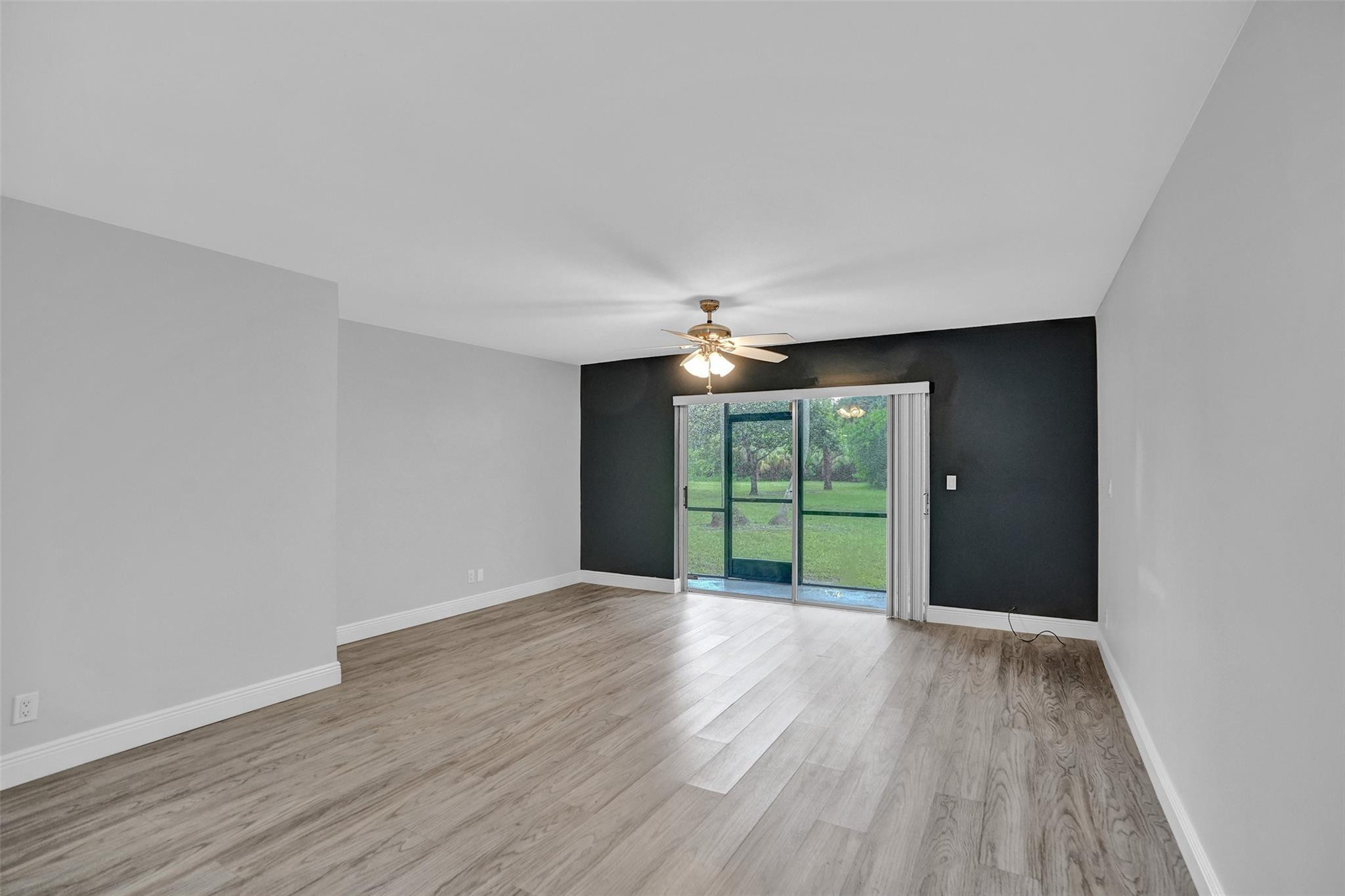 3100 Riverside Drive, Unit 109 Coral Springs, FL 33065 - Photo 7 of 28 a view of an empty room with wooden floor and a window