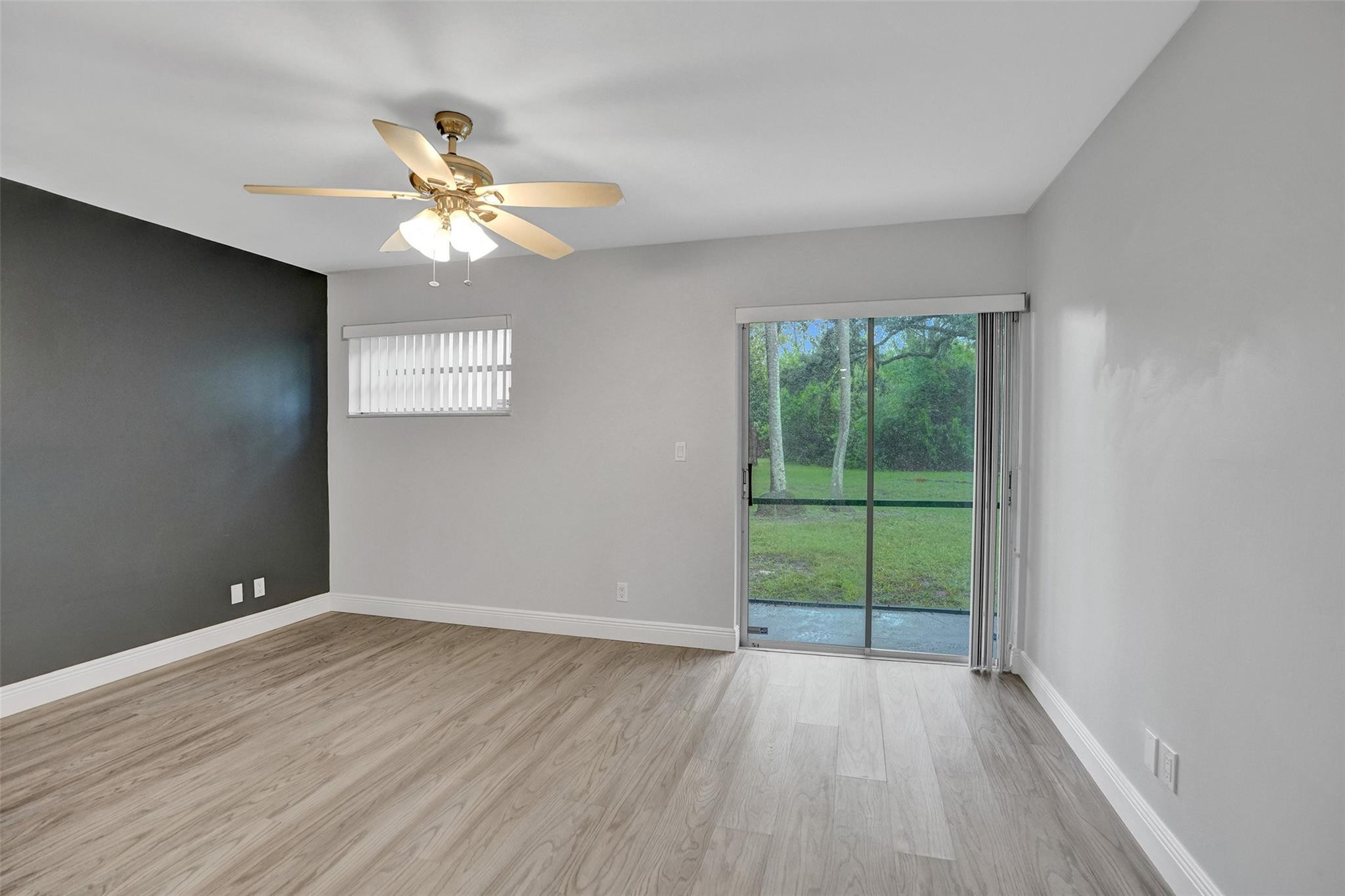 3100 Riverside Drive, Unit 109 Coral Springs, FL 33065 - Photo 10 of 28 wooden floor in an empty room with a window