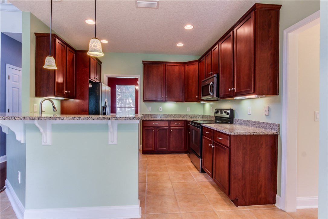 2965 Pinedale Road Fernandina Beach, FL 32034 - Photo 11 of 35 a kitchen with stainless steel appliances granite countertop wooden cabinets a counter top space and a sink
