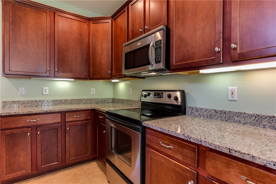 2965 Pinedale Road Fernandina Beach, FL 32034 - Photo 12 of 35 a kitchen with granite countertop wooden cabinets stainless steel appliances and a sink