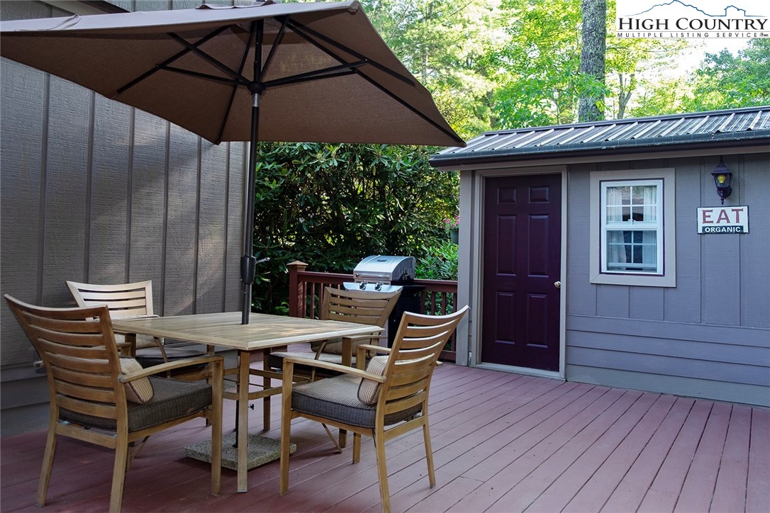 203 Black Pine Road Newland, NC 28657 - Photo 11 of 39 a patio with wooden floor a yard a table and chairs