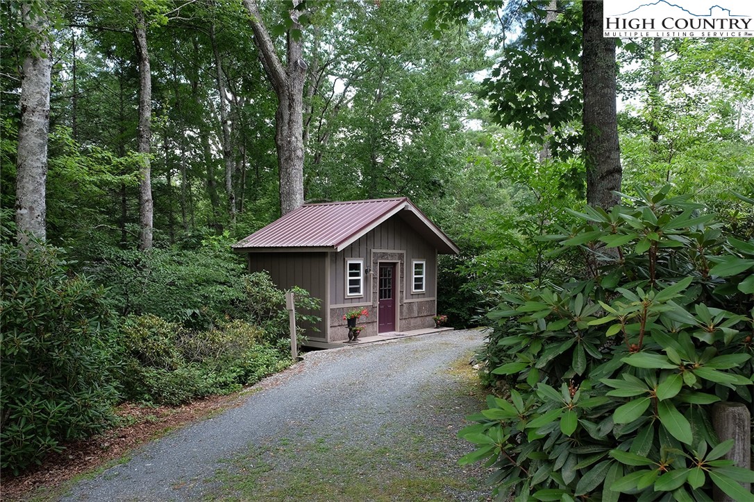 203 Black Pine Road Newland, NC 28657 - Photo 13 of 39 a view of a house with a small yard plants and large trees