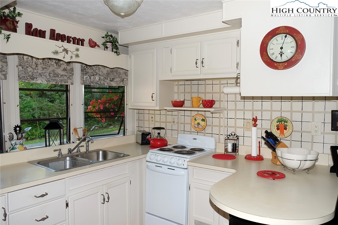 203 Black Pine Road Newland, NC 28657 - Photo 3 of 39 a kitchen with cabinets a window and a potted plant