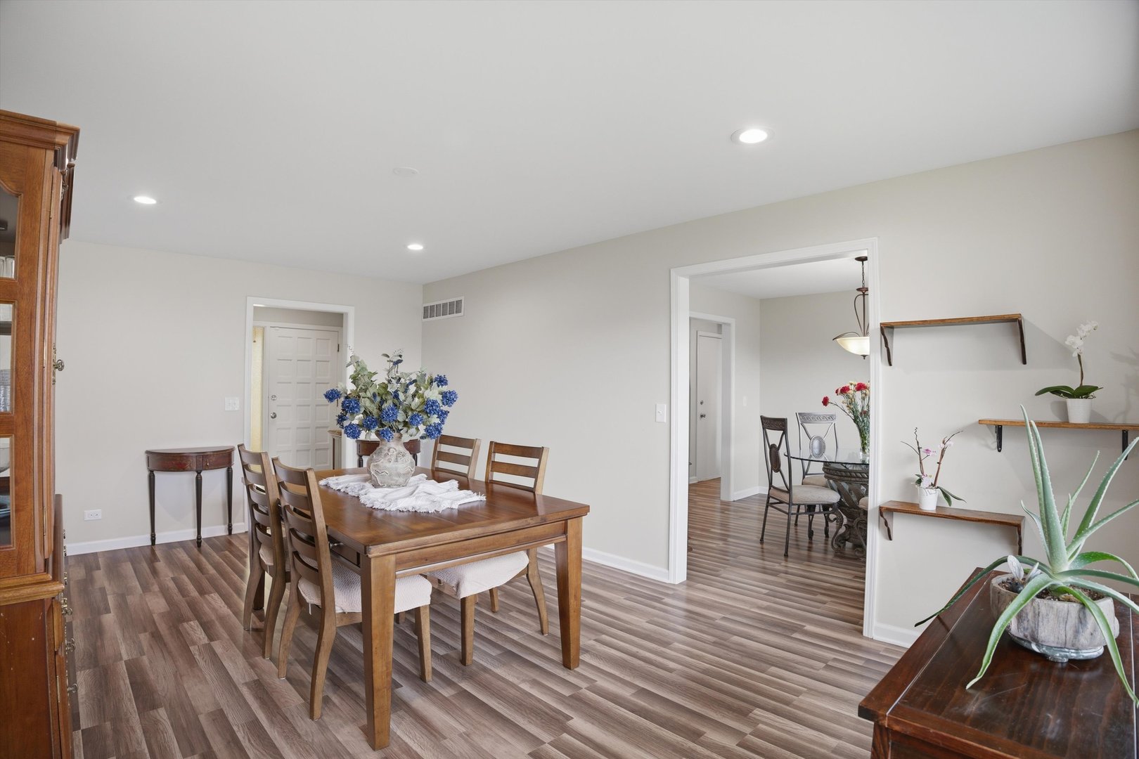 25 Devonshire Circle Elgin, IL 60123 - Photo 7 of 31 a dining room with furniture potted plants and wooden floor