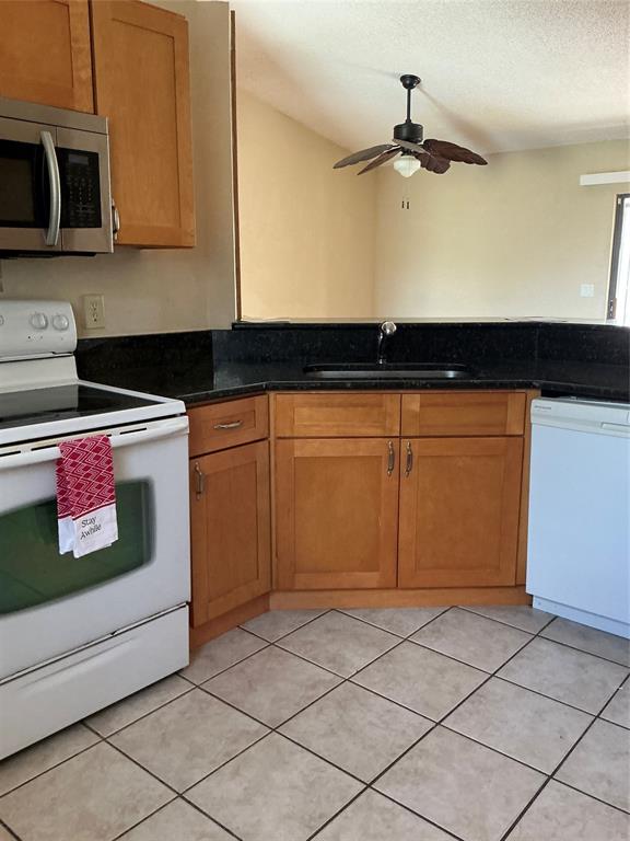 1858 Southwest Capehart Avenue Port St. Lucie, FL 34953 - Photo 5 of 11 a kitchen with stainless steel appliances granite countertop a sink and a stove