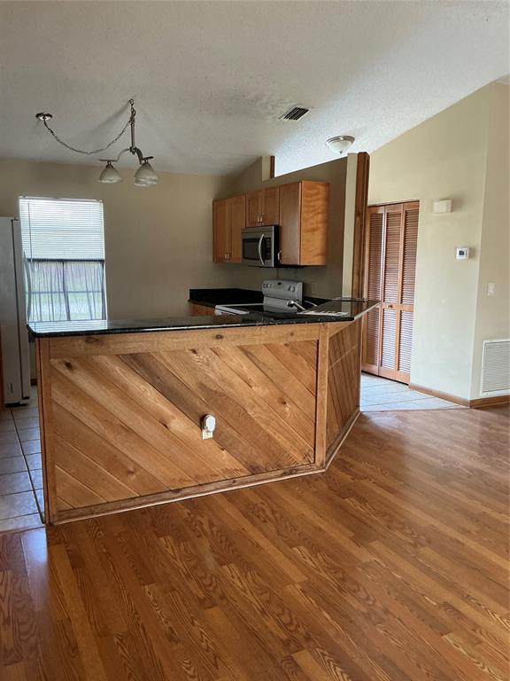 1858 Southwest Capehart Avenue Port St. Lucie, FL 34953 - Photo 7 of 11 a kitchen with stainless steel appliances a stove a refrigerator and a sink