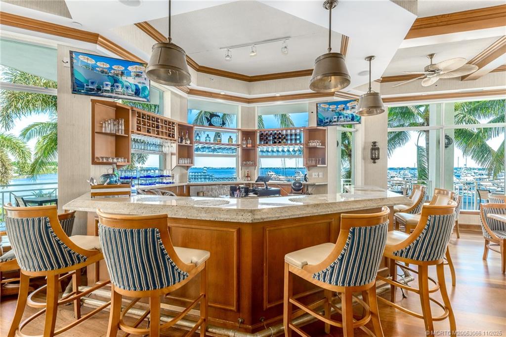 715 Northwest Flagler Avenue, Unit 202 Stuart, FL 34994 - Photo 25 of 26 a dining area with large windows and chandelier