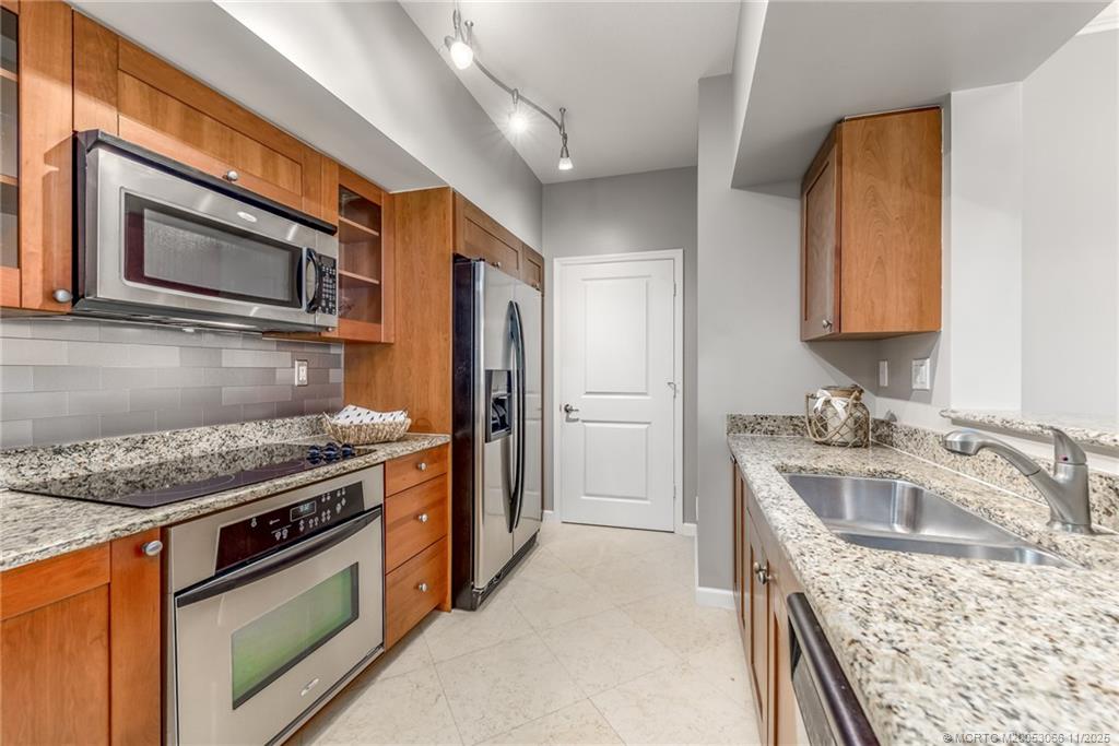 715 Northwest Flagler Avenue, Unit 202 Stuart, FL 34994 - Photo 6 of 26 a kitchen with stainless steel appliances granite countertop a sink stove and refrigerator