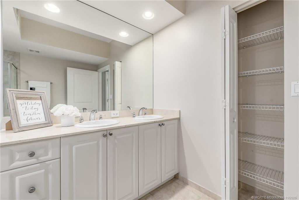 715 Northwest Flagler Avenue, Unit 202 Stuart, FL 34994 - Photo 9 of 26 a bathroom with a double vanity sink and mirror