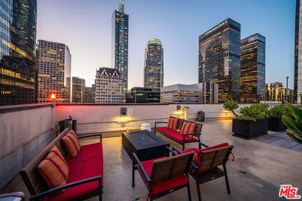 a roof deck with outdoor seating and city view
