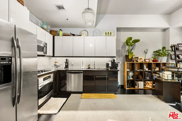 a kitchen with stainless steel appliances granite countertop a sink dishwasher stove and refrigerator
