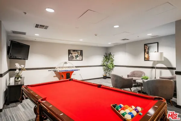 a room with furniture pool table and window