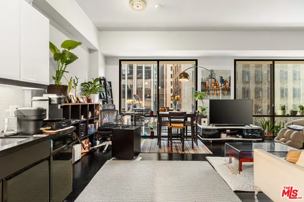 a living room with furniture a large window and a flat screen tv