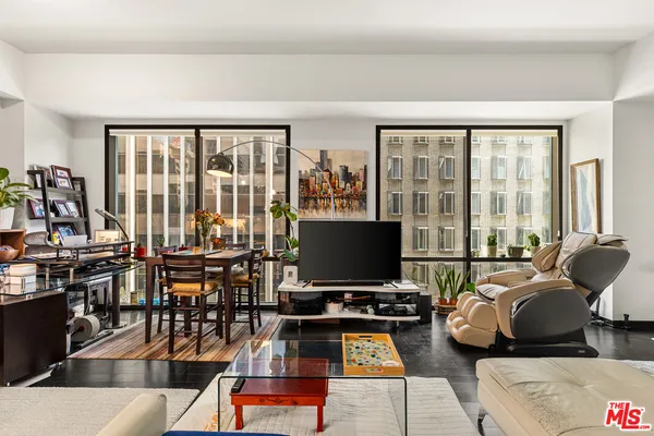a living room with furniture a flat screen tv and a floor to ceiling window