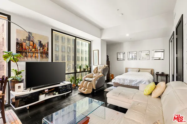 a bedroom with furniture and a flat screen tv