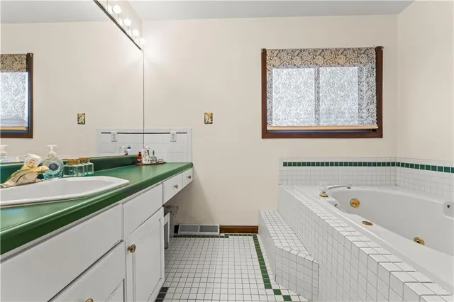 a bathroom with a bathtub sink and mirror